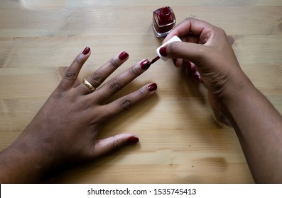 Manicure. Beautiful Hands Of Black Woman Painting Her Nails With Red Nail Polish