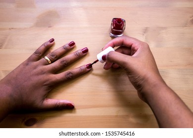 Manicure. Beautiful Hands Of Black Woman Painting Her Nails With Red Nail Polish