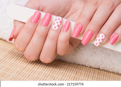 Manicure - Beauty Treatment Photo Of Nice Manicured Woman Fingernails Holding Nail File. Feminine Nail Art With Nice Glitter, Pink And White Nail Polish.