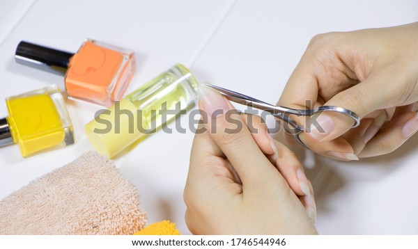 Manicure.\
Cut your fingernails with small nail scissors. Trim your nails.\
Young woman taking care of her nails. Hygiene, clipping, cutter,\
self, skincare, procedure, routine,\
treatment.