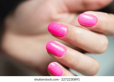 Manicure with gel polish. Bright female pink manicure.