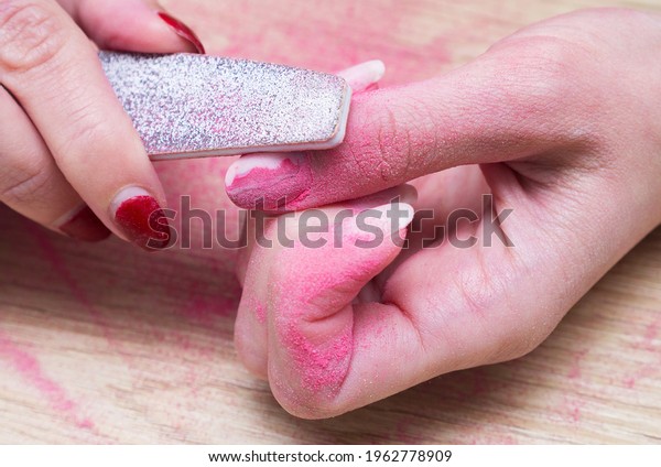 Manicure at home, concept. Self-removal of old\
polish gel from nails with a nail\
file.