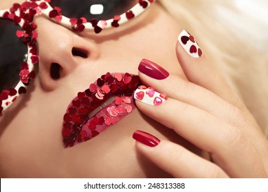 	  Manicure and lips with hearts of different shapes and colors on the girl with the glasses.