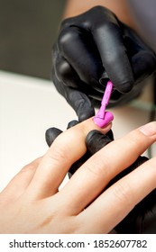 Maniküre, die rosafarbene Nagellack auf weibliche Nageln im Nagelsalon aufträgt