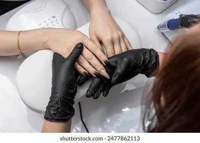 Manicure master in black gloves. Manicure with long nails. Master checks the nails before starting manicure - Powered by Shutterstock