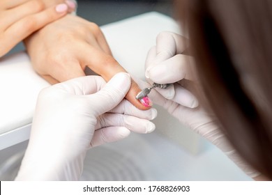 Manicure master uses an electric nail machine to remove nail polish hands in nail salon - Powered by Shutterstock