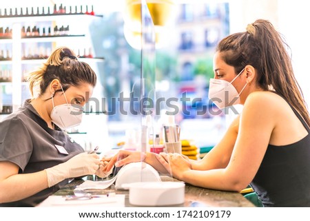 Manicure and pedicure beauty salon with security measures and people with masks, performing a pedicure treatment. Reopening after the corod-19 pandemic. Coronavirus