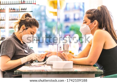 Manicure and pedicure beauty salon with security measures and people with masks. Reopening after the corod-19 pandemic. Coronavirus