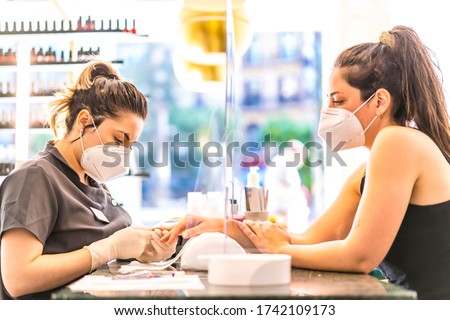 Manicure and pedicure salon with security measures and people with masks, performing a pedicure treatment. Reopening after the corod-19 pandemic. Coronavirus