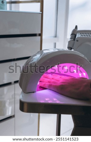 Manicure process. Drying nails in a device with ultraviolet lamps. High quality photo