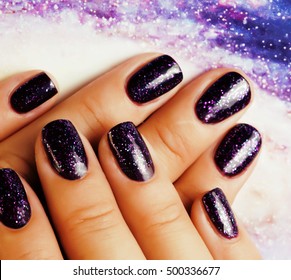 Manicure Stylish Concept: Woman Fingers With Nails Purple Glitter On Nails Like Cosmos, Universe Background