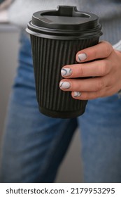 Manicured Female Hands Holding Black Eco Recycling Coffee Cup With Stylish Blue Nails And Minimalistic Design. Trendy Modern Design Manicure. Gel Nails. Skin Care. Wellness Beauty Treatment. Nail Care