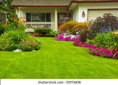 Manicured House and Garden displaying annual and perennial gardens in full bloom. - Powered by Shutterstock