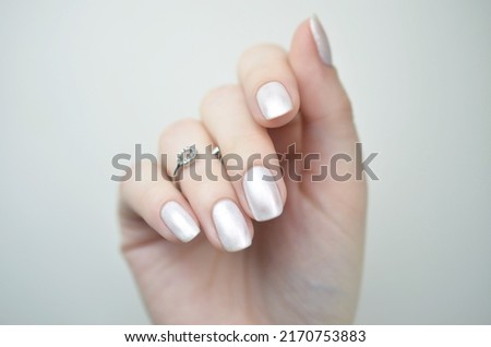 Manicured nails with pearlescent nail polish isolated on white background