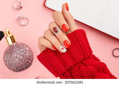 Manicured Womans Hand In Warm Wool Red Sweater. Fashionable Valentines Day Nail Design