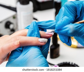 Manicurist applies a layer of gel polish to the client’s nail. Brush pink nail polish. Covering the nail plate with nail polish - Shutterstock ID 1818251084