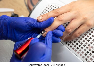 The Manicurist Applies A Topcoat To The Finished Hybrid Nails With A Brush.
