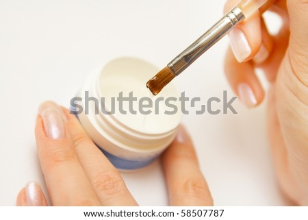 Manicurist applying nail polish on female fingers