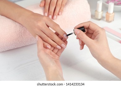 Manicurist Applying Polish On Client's Nails At Table, Closeup. Spa Treatment