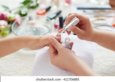 Manicurist Applying Transparent Base Coat To Nail