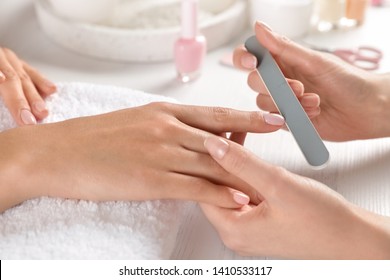 Manicurist Filing Client's Nails At Table, Closeup. Spa Treatment