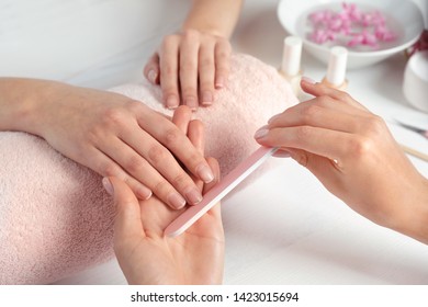 Manicurist Filing Client's Nails At Table, Closeup. Spa Treatment