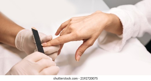 Manicurist Filing Woman's Nails At Her Working Table. Nail Care Process, Close-up