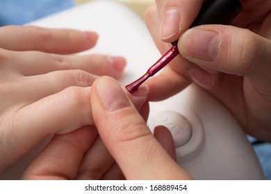 manicurist paint your nails on the hand