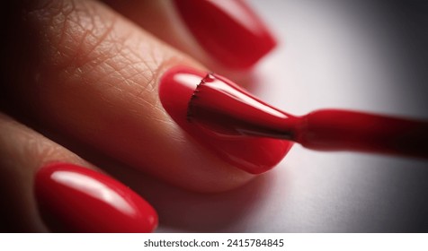 Manicurist paints nails with red gel polish. Application of nail polish. Manicured red nails concept