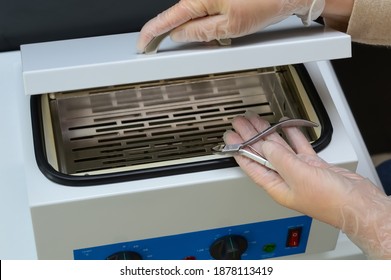 manicurist prepare nail nipper for hot air sterilization in autoclave from from bacteria and viruses - Shutterstock ID 1878113419