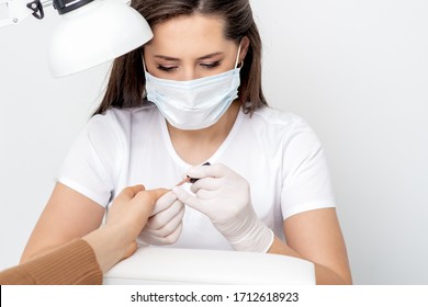 Manicurist Wearing Protective Mask Painting Female Nails With Nail Polish In Manicure Salon.