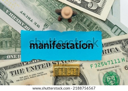 manifestation.The word is written on a slip of paper,on colored background. professional terms of finance, business words, economic phrases. concept of economy.
