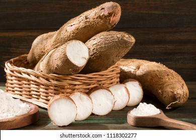Manihot esculenta (cassava, yuca, manioc, mandioca, Brazilian arrowroot) and tapioca on wooden background. Selective focus
