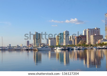 Manila bay Philippines city scape with yachts and luxury boats on summer afternoon.