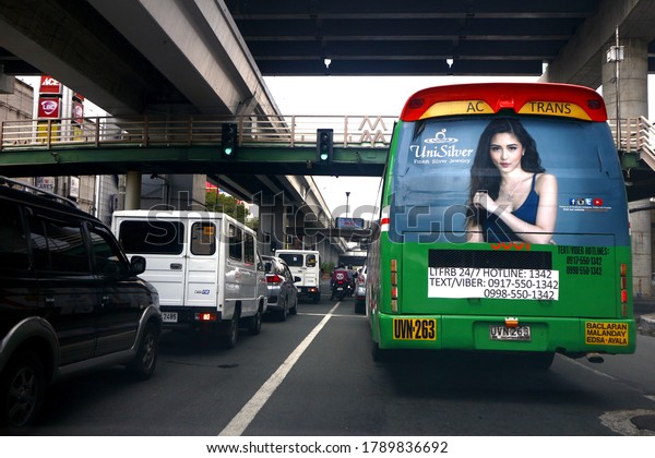 Manila City,\
Philippines - July 27, 2020: Passenger bus and other vehicles at an\
intersection with\
stoplight.