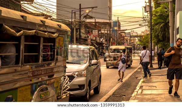 MANILA, PHILIPPINES -\
CIRCA MARCH 2018: View on daily life on the streets of the city as\
cars and pedestrians pass by during the day circa March, 2018 in\
Manila, Philippines.