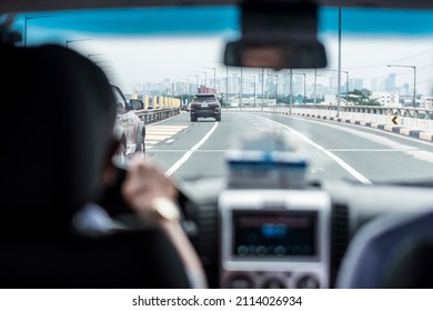 Manila, Philippines - Jan 2022: Driving along Skyway towards the city center. Shot inside the cabin from the perspective of the passenger in the backseat.