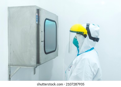 Manila, Philippines - Jan 2022: A Medical Technician Operates A Pass Box Containing Test Samples At A Cleanroom At A Laboratory.