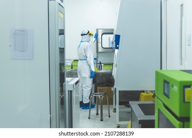 Manila, Philippines - Jan 2022: A Medical Technician Opens A Pass Box To Receive Test Samples At A Cleanroom At A Laboratory.