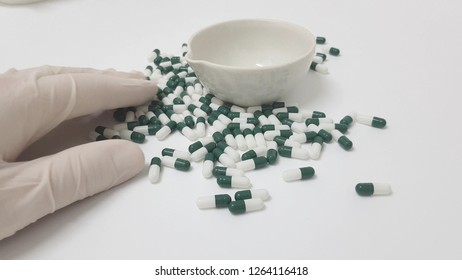 Manipulating green white capsules in the pharmacy laboratory