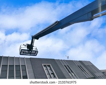 Manlift Crane With Platform Lifting To The Roof Top Of A Building