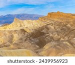 Manly Beacon Towers Over The Striped Badlands With The Panamint Mountains in The Distance From Zabriskie Point Overlook, Death Valley National Park, California, USA