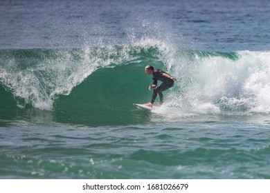 MANLY, NSW/AUSTRALIA – MARCH 2020: Young Adults Catching Waves Surfing At Manly Beach On A Bright Warm Sunny Day On Clear Blue Water