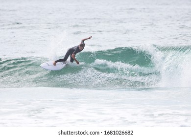 MANLY, NSW/AUSTRALIA – MARCH 2020: Young Adults Catching Waves Surfing At Manly Beach On A Bright Warm Sunny Day On Clear Blue Water