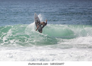 MANLY, NSW/AUSTRALIA – MARCH 2020: Young Adults Catching Waves Surfing At Manly Beach On A Bright Warm Sunny Day On Clear Blue Water