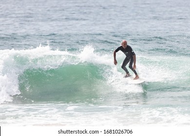 MANLY, NSW/AUSTRALIA – MARCH 2020: Young Adults Catching Waves Surfing At Manly Beach On A Bright Warm Sunny Day On Clear Blue Water