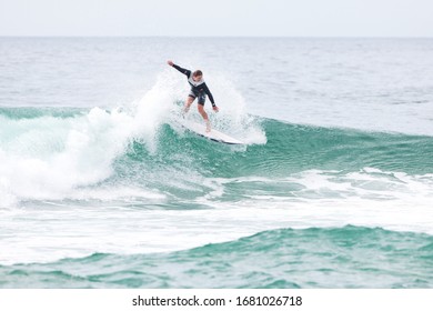 MANLY, NSW/AUSTRALIA – MARCH 2020: Young Adults Catching Waves Surfing At Manly Beach On A Bright Warm Sunny Day On Clear Blue Water