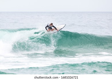 MANLY, NSW/AUSTRALIA – MARCH 2020: Young Adults Catching Waves Surfing At Manly Beach On A Bright Warm Sunny Day On Clear Blue Water