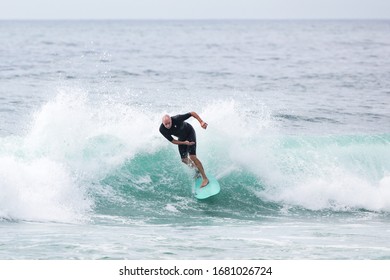 MANLY, NSW/AUSTRALIA – MARCH 2020: Young Adults Catching Waves Surfing At Manly Beach On A Bright Warm Sunny Day On Clear Blue Water