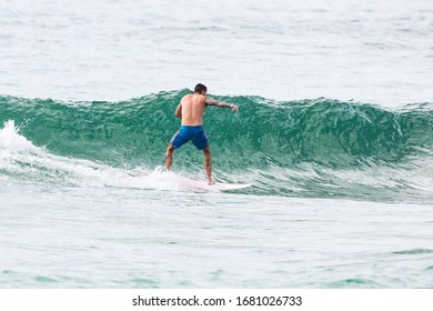 MANLY, NSW/AUSTRALIA – MARCH 2020: Young Adults Catching Waves Surfing At Manly Beach On A Bright Warm Sunny Day On Clear Blue Water